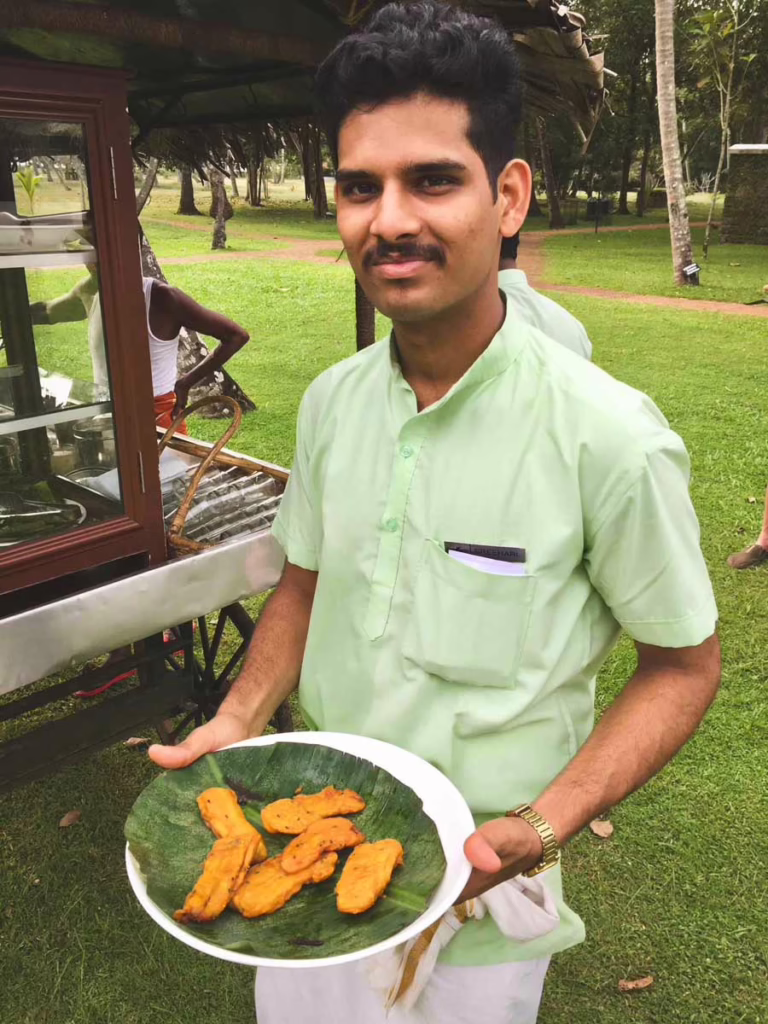a young man with a green shirt holding a plate of banana fritters