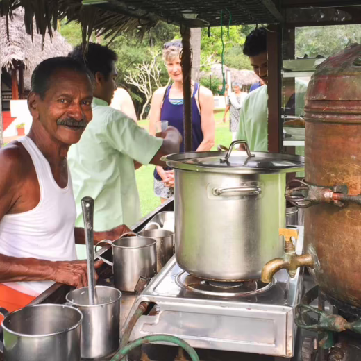 a man in a white top and orange bottom cooking
